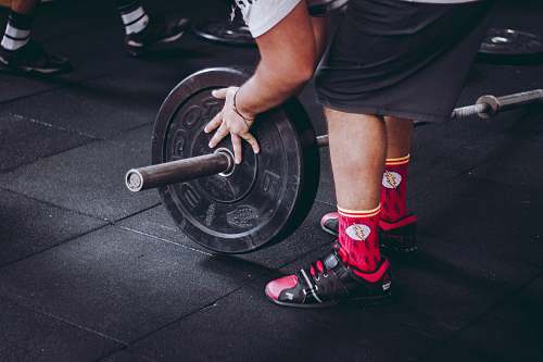 gambaru crossfit person arranging barbell plate muscles
